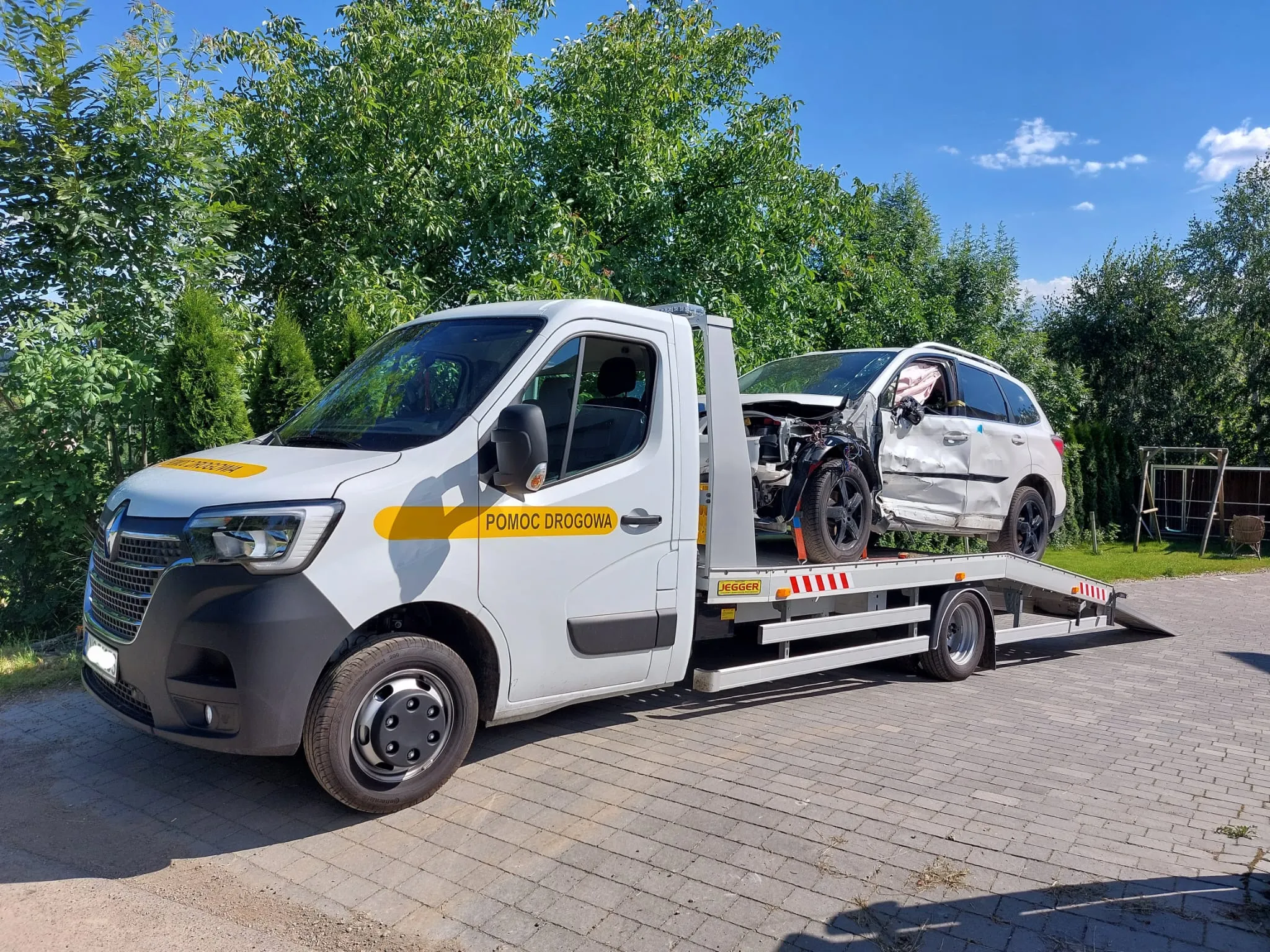 Koło samochodu przymocowanego pasem do lawety.