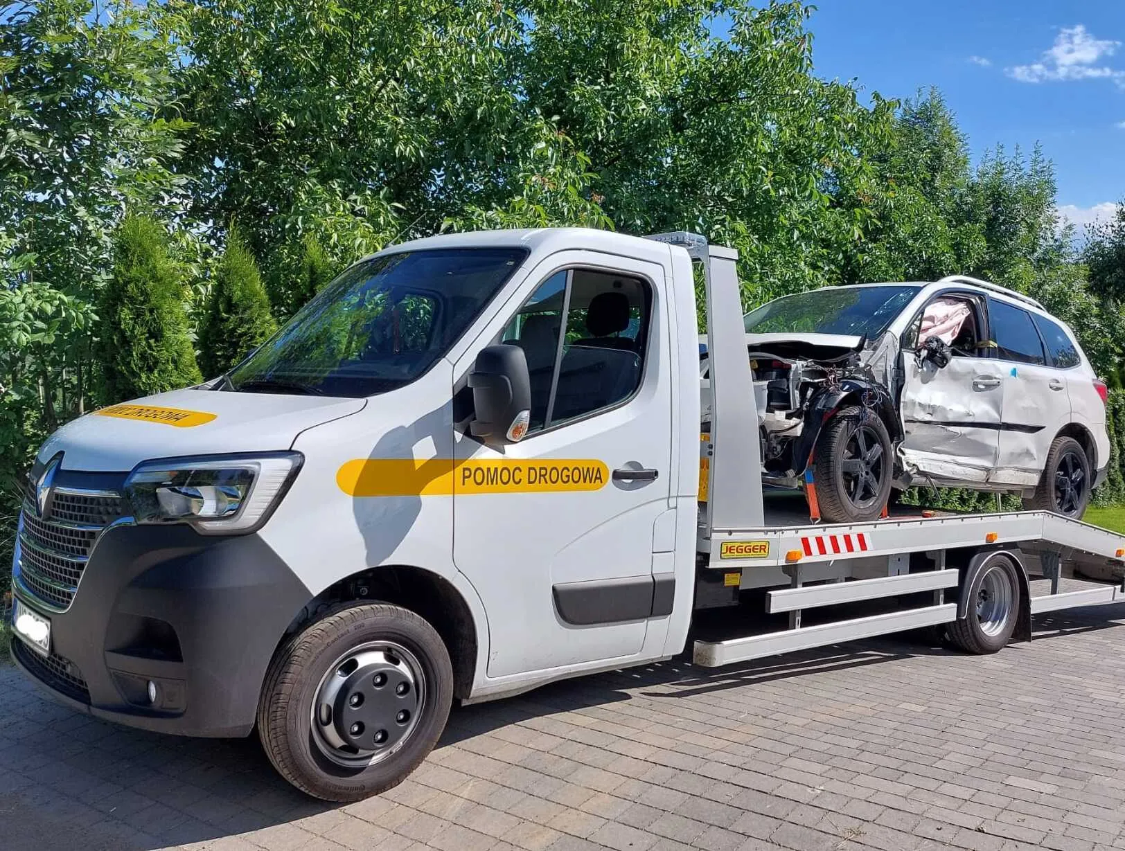 Koło samochodu przymocowanego pasem do lawety.